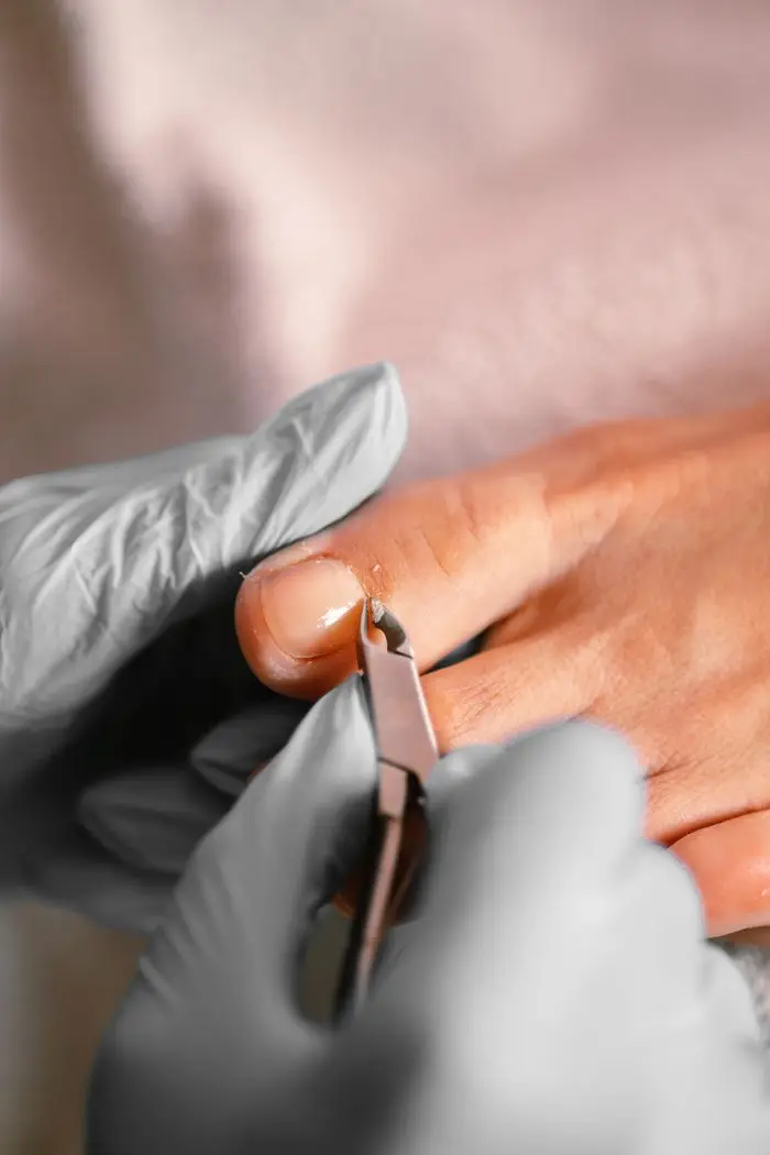 services-02 Close-up of a professional pedicure treatment using cuticle tongs
