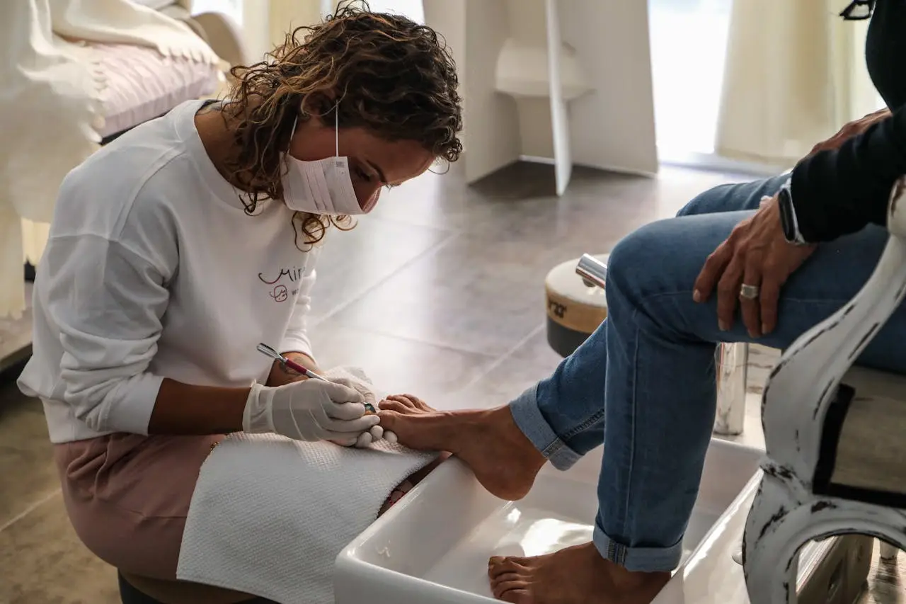 hero-img-02 A beauty technician performs a pedicure, providing professional foot care at a salon.