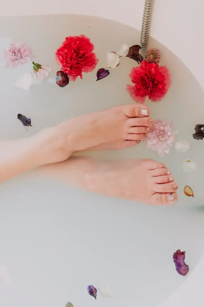 ours-journey A serene image of feet soaking in a floral bath surrounded by vibrant flowers and petals.